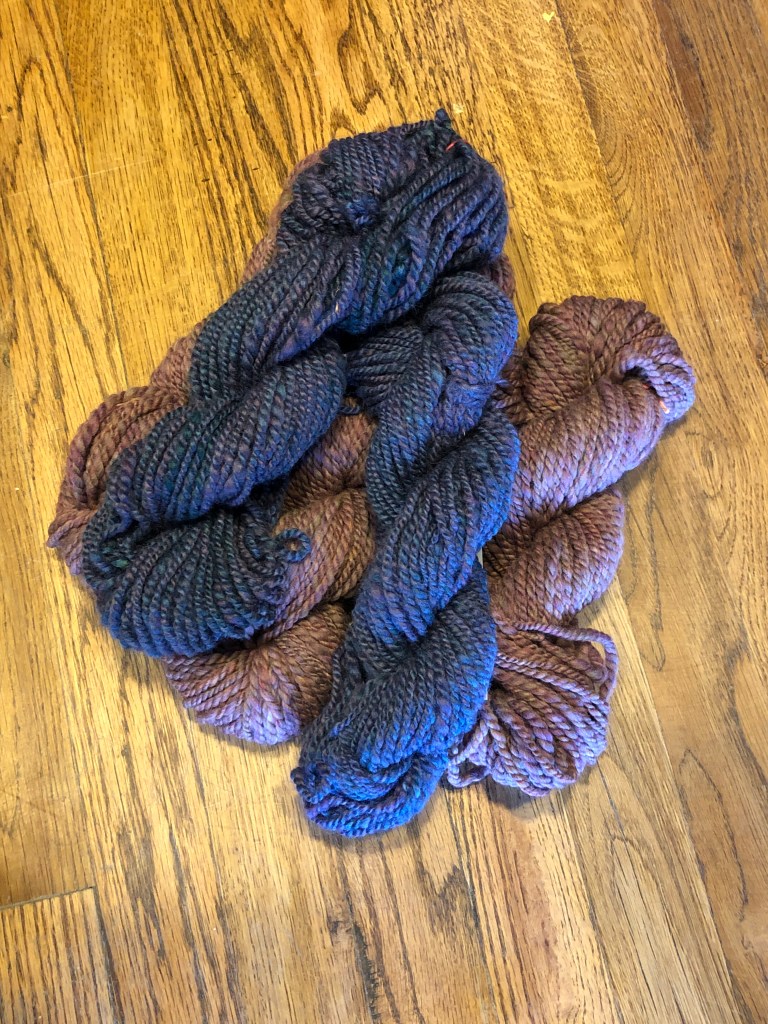 2 blue wool skeins with purple highlights and 3 purple wool skeins with blue highlights