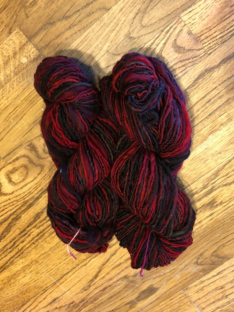 Red and black variegated Ramboillet- Columbia skein.